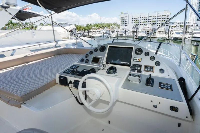 Slide: The Image of 2006 Aicon Flybridge yacht helm with navigation controls and marina view. - 22