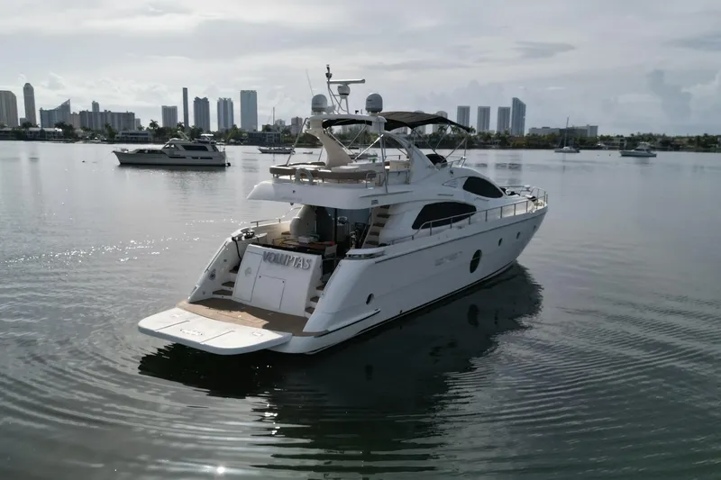 Slide: The Image of Luxury 2006 Aicon Flybridge yacht on calm water with city skyline backdrop. - 5