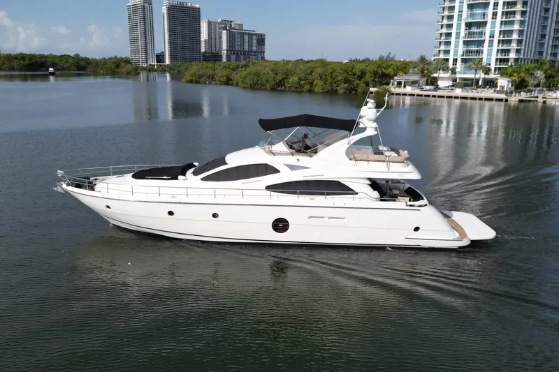 Slide: The Image of 2006 Aicon Flybridge yacht cruising on calm waters near modern high-rise buildings. - 63