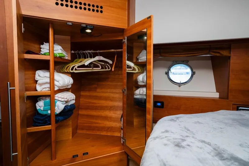 Slide: The Image of Luxurious 2006 Aicon Flybridge yacht interior with wooden wardrobe and porthole view. - 92