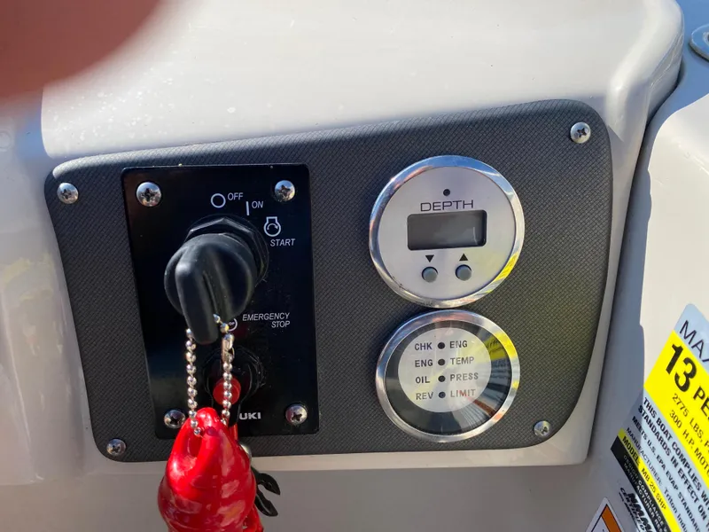 Slide: The Image of Control panel of a 2016 Manitou 25 Aurora boat with ignition and depth gauge. - 15