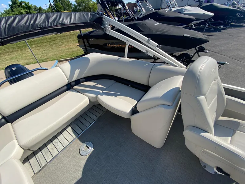 Slide: The Image of 2016 Manitou 25 Aurora boat interior with beige seating and carpeted floor. - 19