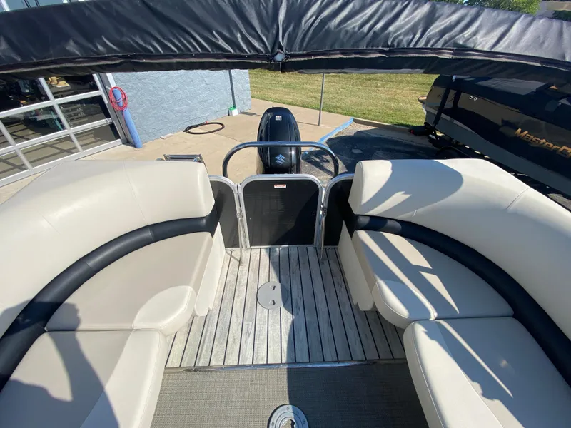 Slide: The Image of 2016 Manitou 25 Aurora boat interior with seating and canopy, viewed from the deck. - 22