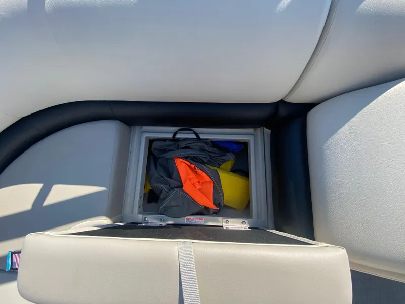 Slide: The Image of Storage compartment on 2016 Manitou 25 Aurora boat with life jackets and gear. - 24