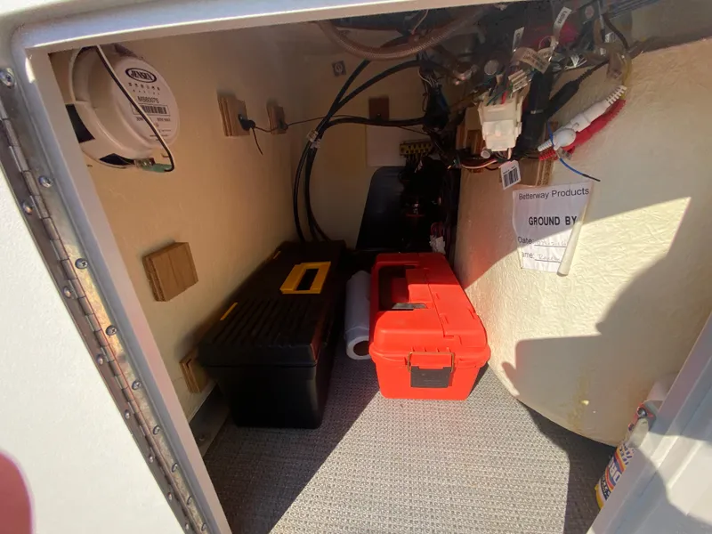 Slide: The Image of Interior storage of 2016 Manitou 25 Aurora boat with toolboxes and wiring. - 25