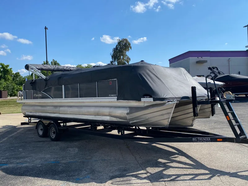 Slide: The Image of 2016 Manitou 25 Aurora pontoon boat on trailer, covered, parked outdoors. - 30