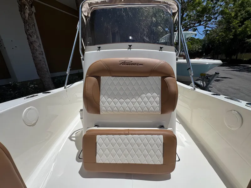 Slide: The Image of 2026 Pioneer 180 Islander boat interior with tan and white diamond-stitched seating. - 10