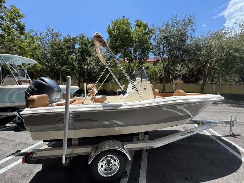 Slide: The Image of 2026 Pioneer 180 Islander boat on trailer, parked outdoors under clear sky. - 2