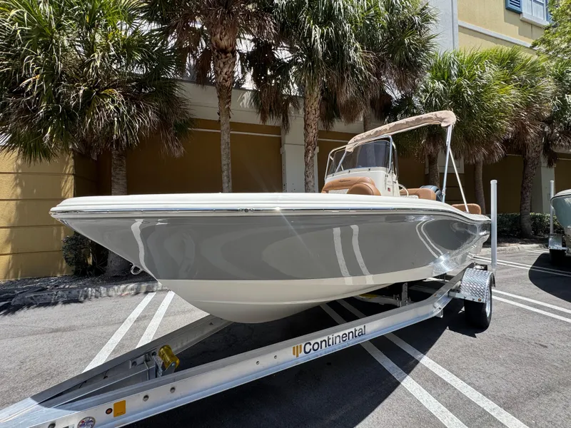 Slide: The Image of 2026 Pioneer 180 Islander boat on trailer, parked under palm trees. - 3