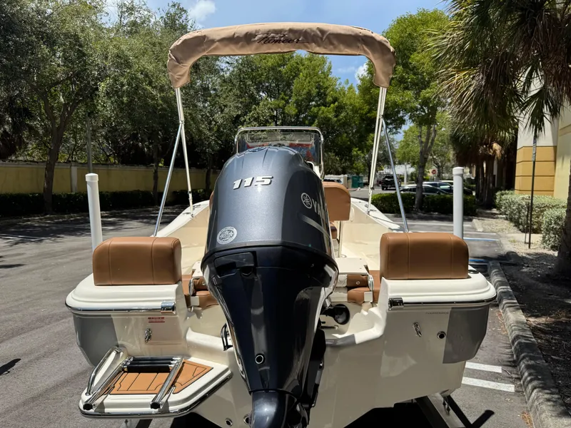 Slide: The Image of 2026 Pioneer 180 Islander boat with Yamaha 115 engine, parked outdoors. - 4