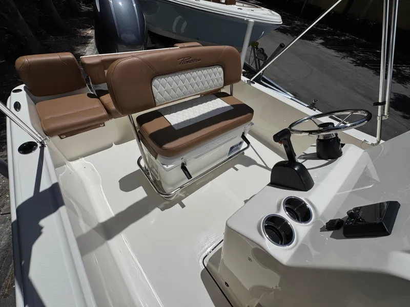 Slide: The Image of 2026 Pioneer 180 Islander boat interior with brown and white seating, steering console, and cup holders. - 5