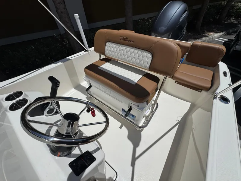Slide: The Image of 2026 Pioneer 180 Islander boat interior with steering wheel and cushioned seating. - 7