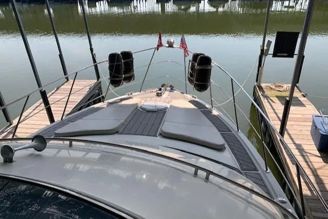 Slide: The Image of 2005 Carver 444 Cockpit Motor Yacht docked, view from bow, calm water background. - 13