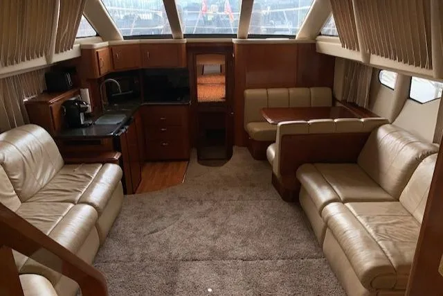 Slide: The Image of 2005 Carver 444 Cockpit Motor Yacht interior with beige leather seating and wood accents. - 15