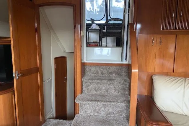 Slide: The Image of Interior of 2005 Carver 444 Cockpit Motor Yacht with carpeted stairs and wooden cabinetry. - 16