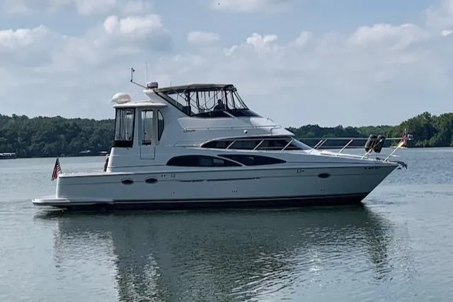 Slide: The Image of 2005 Carver 444 Cockpit Motor Yacht on calm water, side view. - 2