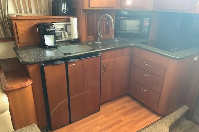 Slide: The Image of 2005 Carver 444 Cockpit Motor Yacht kitchen with appliances and wooden cabinetry. - 20