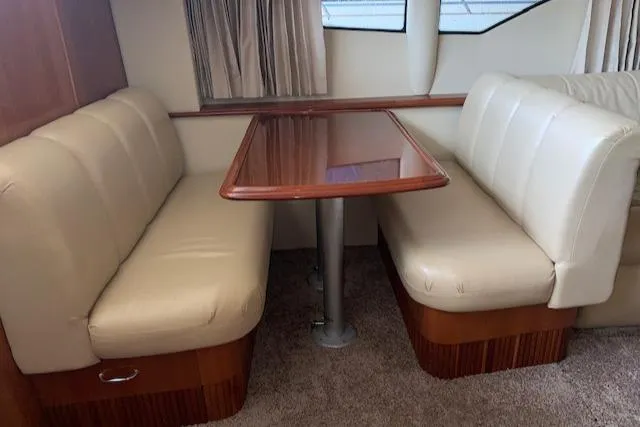 Slide: The Image of 2005 Carver 444 Cockpit Motor Yacht interior with beige seating and wooden table. - 21