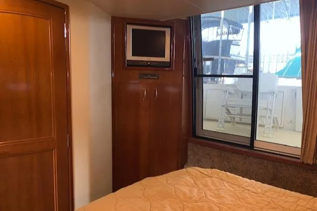 Slide: The Image of 2005 Carver 444 Cockpit Motor Yacht interior with bed, TV, and window view. - 28