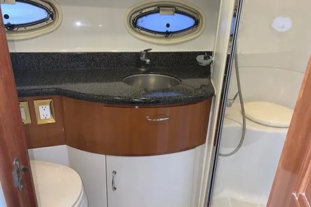 Slide: The Image of 2005 Carver 444 Cockpit Motor Yacht bathroom with sink, shower, and porthole windows. - 29