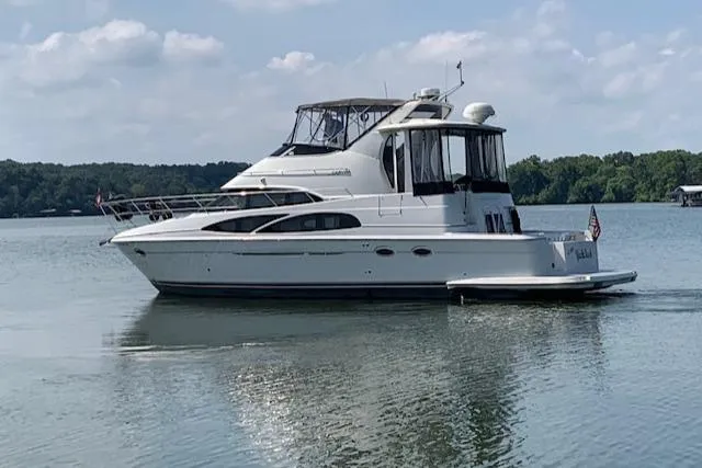 Slide: The Image of 2005 Carver 444 Cockpit Motor Yacht on a serene lake. - 3