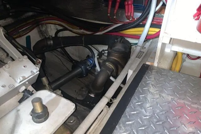 Slide: The Image of Engine room of 2005 Carver 444 Cockpit Motor Yacht with visible pipes and wiring. - 32