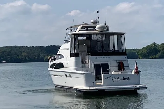Slide: The Image of 2005 Carver 444 Cockpit Motor Yacht on a serene lake. - 4