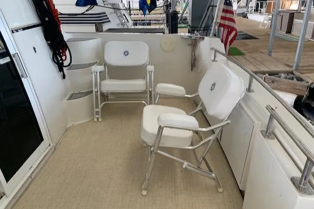 Slide: The Image of 2005 Carver 444 Cockpit Motor Yacht with white seating and American flag. - 6