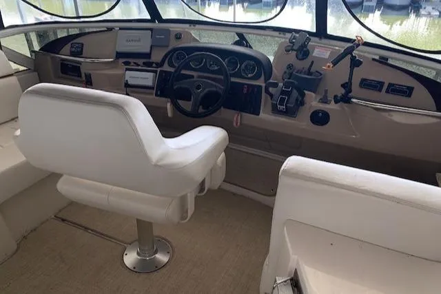 Slide: The Image of 2005 Carver 444 Cockpit Motor Yacht helm with white seating and navigation controls. - 9