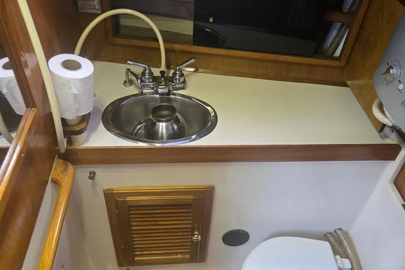 Slide: The Image of 1987 Saturna 33 yacht bathroom with sink, faucet, and toilet paper holder. - 10