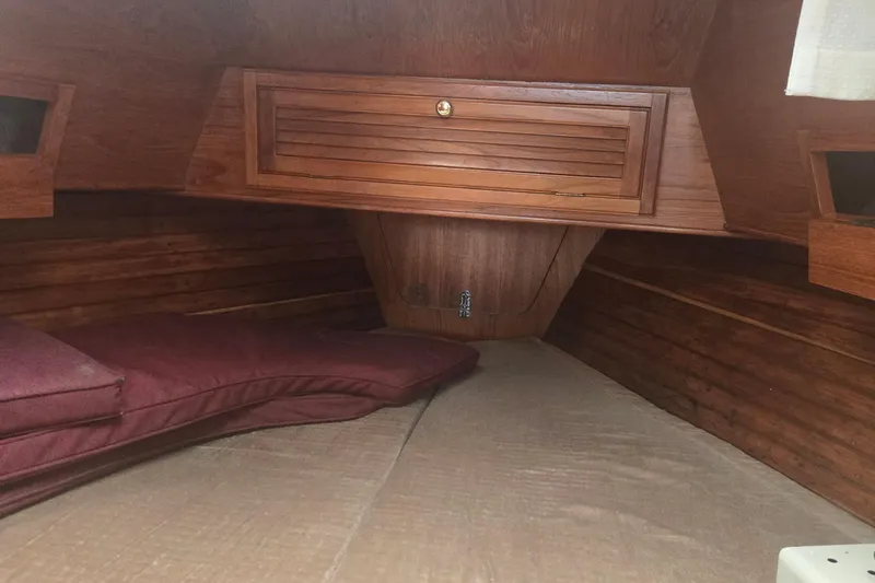 Slide: The Image of Interior cabin of a 1987 Saturna 33 sailboat with wooden finish and cushions. - 11