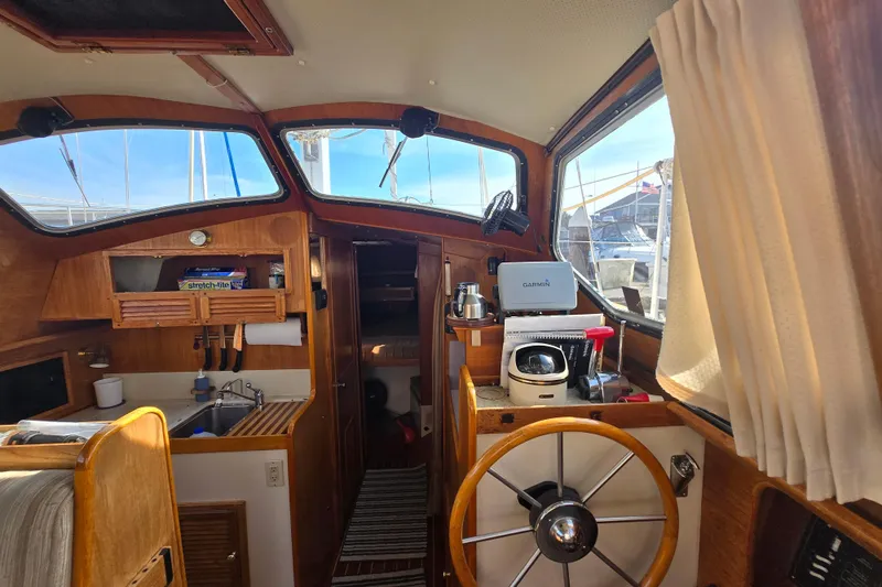 Slide: The Image of Interior of a 1987 Saturna 33 sailboat with wooden helm and navigation equipment. - 15