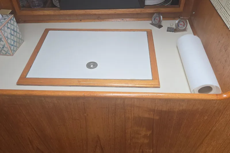 Slide: The Image of 1987 Saturna 33 interior with wooden countertop, paper towel roll, and thermometers. - 17