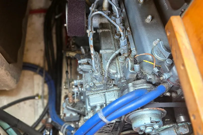 Slide: The Image of Engine compartment of a 1987 Saturna 33 boat, featuring visible hoses and components. - 19