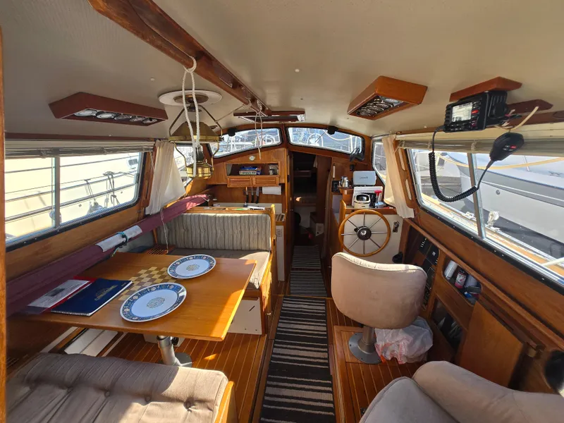 Slide: The Image of Interior of 1987 Saturna 33 sailboat with wooden furnishings and dining area. - 4