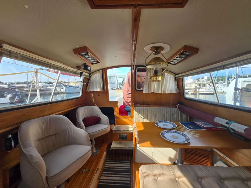 Slide: The Image of Cozy interior of a 1987 Saturna 33 yacht with seating and dining area. - 5