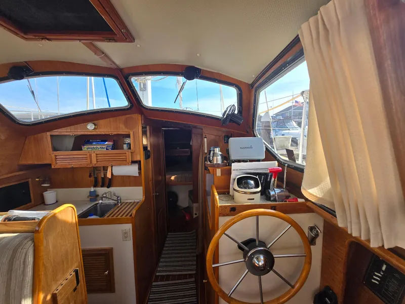 Slide: The Image of Interior of a 1987 Saturna 33 sailboat with wooden helm and navigation equipment. - 6