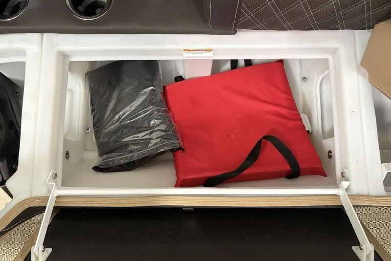 Slide: The Image of 2025 Barletta L25U boat seat storage compartment, open with beige and black upholstery. - 11