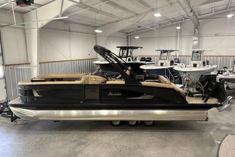 Slide: The Image of 2025 Barletta L25U boat interior with tan leather seating and storage compartment open. - 3