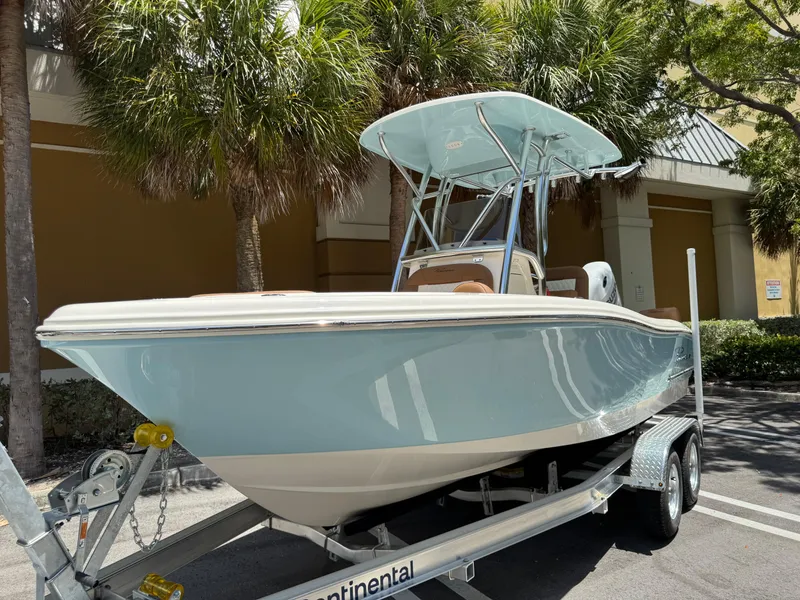The Image of 2026 Pioneer 202 Sportfish boat on trailer, parked outdoors under palm trees. - 0