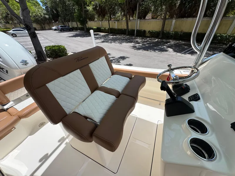 Slide: The Image of 2026 Pioneer 202 Sportfish boat interior with brown and white seating, steering wheel, and controls. - 10