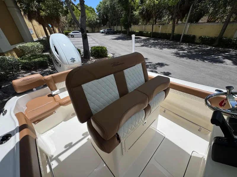 Slide: The Image of 2026 Pioneer 202 Sportfish boat interior with cushioned seating and Suzuki outboard motor. - 8