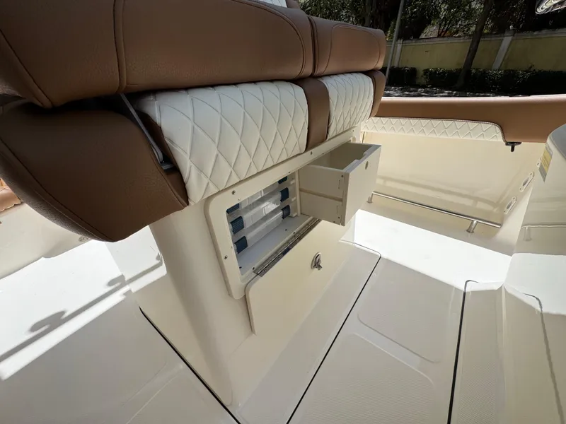 Slide: The Image of 2026 Pioneer 202 Sportfish boat interior with storage compartment and cushioned seating. - 9