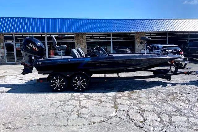 The Image of 2026 iKon VLX 20 boat on trailer outside dealership with blue awning. - 0