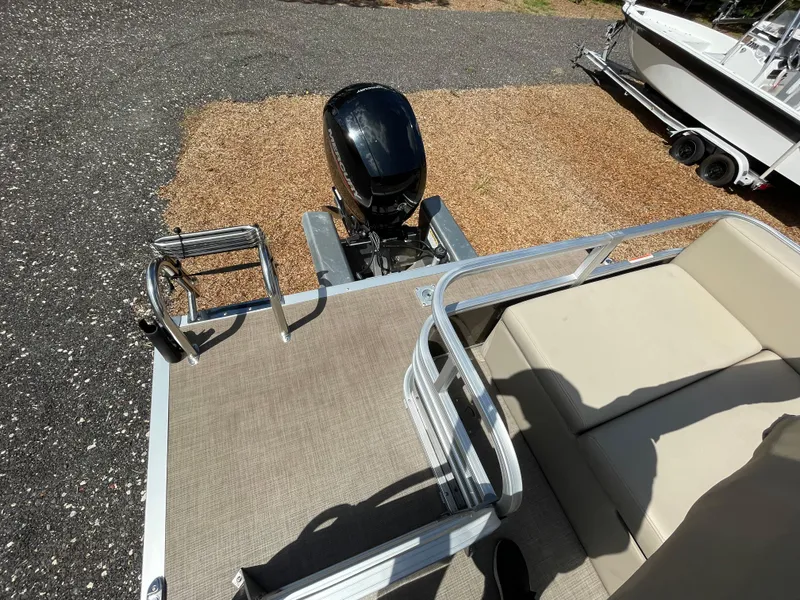 Slide: The Image of 2023 Bass Tracker Sportfish 24 DLX boat deck with seating and motor. - 10