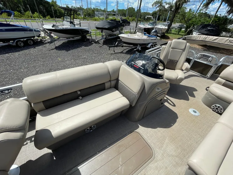 Slide: The Image of 2023 Bass Tracker Sportfish 24 DLX interior with beige seating and steering console. - 4