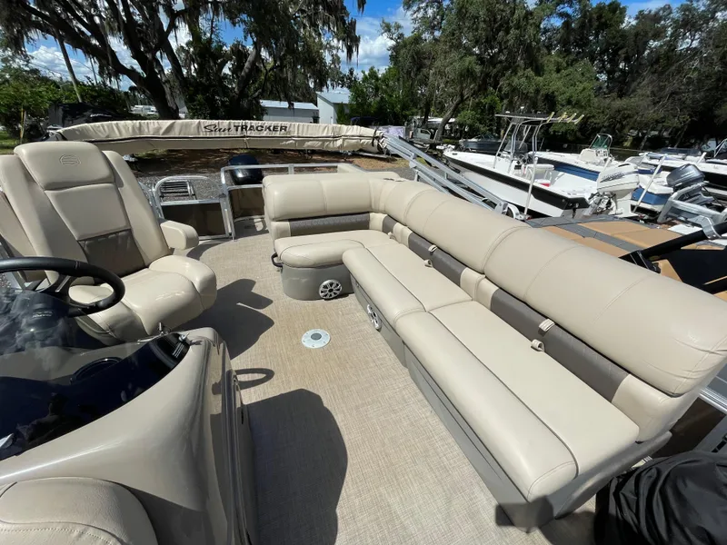 Slide: The Image of 2023 Bass Tracker Sportfish 24 DLX pontoon boat with beige seating and spacious deck. - 5