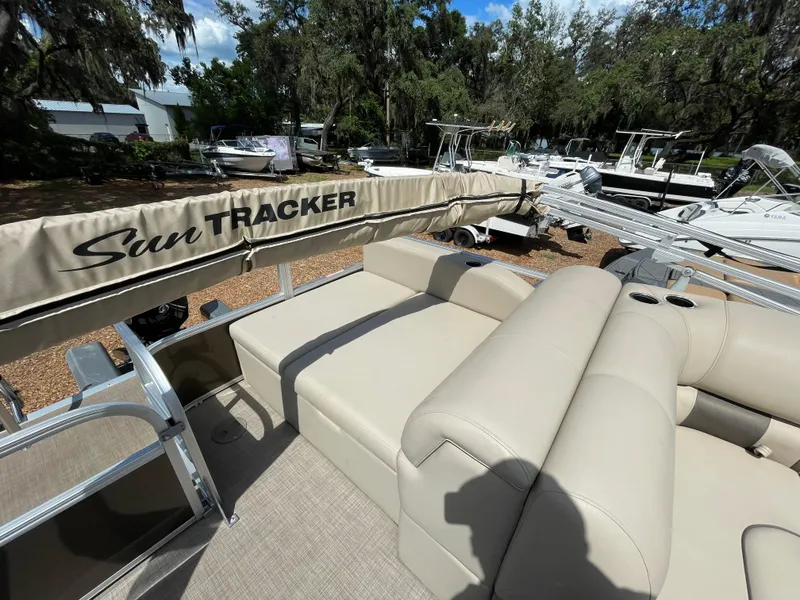 Slide: The Image of 2023 Bass Tracker Sportfish 24 DLX pontoon boat with beige seating and Sun Tracker canopy. - 6
