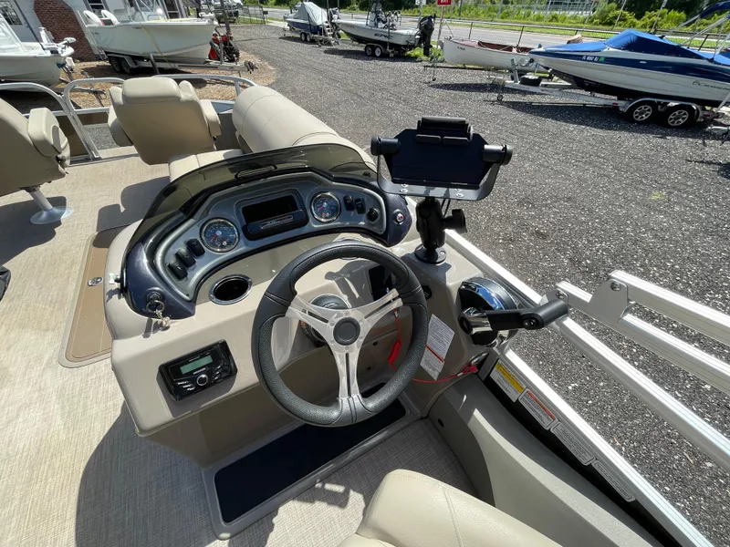 Slide: The Image of 2023 Bass Tracker Sportfish 24 DLX boat dashboard with steering wheel and controls. - 8