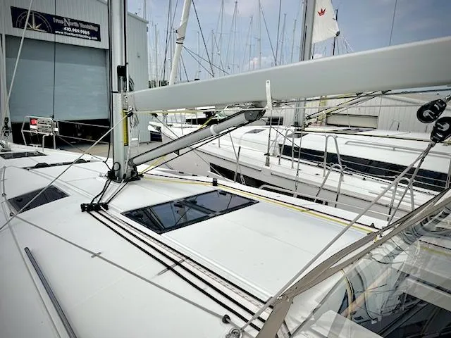 Slide: The Image of 2023 Jeanneau Sun Odyssey 440 sailboat docked at marina, showcasing sleek design and rigging. - 11